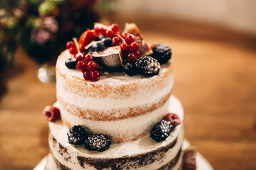 Wedding cake at the celebration. Stylish dessert at the wedding. Cutting the cake with the bride and groom.