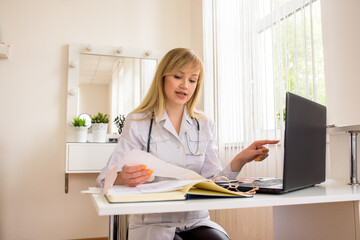 Online doctor consultation at the office. young doctor working on a laptop. speaks and treats distance. conversation with web patient.