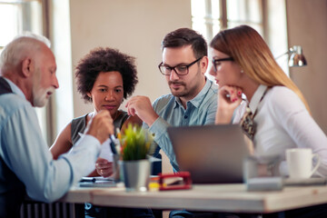 Coworkers discussing about project in office