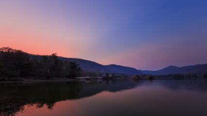 Fototapeta na wymiar Bamboo houses with mountain on the calm lake backgroud in the morning at Khao wong reservoir, Suphanburi province, Thailand