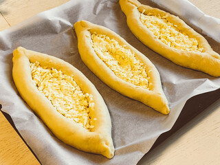 Harvest of khachapuri in Adjara on baking paper on a baking sheet