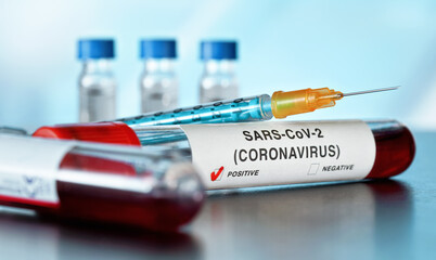 Naklejka premium Sample vial with blood, label says coronavirus test, positive result. Blurred laboratory equipment background. Covid-19 testing during outbreak concept