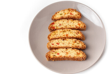 Popular Italian Biscotti or Cantucci biscuit cookies stuffed with candied fruit served on brown plate with copy space.