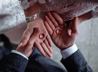 The bride and groom are holding wedding rings