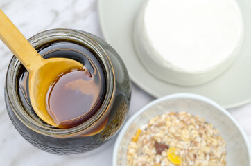 Fresh cheese with honey in white plate. Honey with wooden spoon