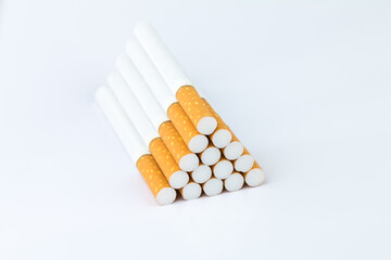 Closeup of many cigarettes The cigarette end is brown and the tip is white. Arranged in a triangle On a white background