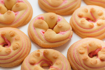 Cookie biscuit with pink sugar cream icing isolated on white background