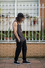 Modelo de moda urbana con tatuajes posando en una urbanización
