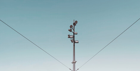 Street light pole in spiral with metal wire supporting , blue background , minimalist and modern street green energy pole. 