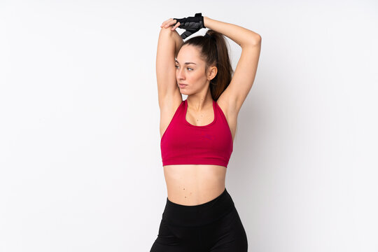 Young sport brunette woman over isolated white background stretching © luismolinero