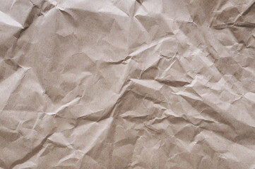 Background from old crumpled light brown wrapping vintage paper. The texture of cardboard made from recycled materials.