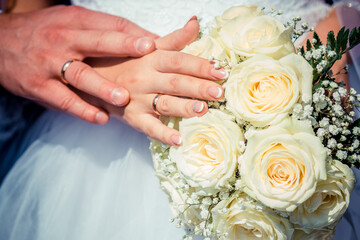 newlyweds, close-up hands with rings, joined together, hold hands