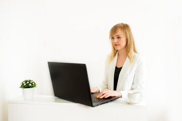 Remote work.Entrepreneur woman wearing white jacket working with a laptop sitting on a couch at home.Online consultation tax lawyer, accountant in the office