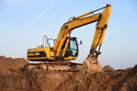 Large excavator working at construction site. Backhoe during earthworks on sand quarry. Earth-moving heavy equipment