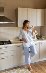 young woman in the kitchen drinking coffee