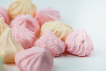 Colorful meringue sweets dessert on white background. Yellow mint green and pink