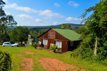 Fototapeta na wymiar A beautiful log wooden cabin house in Sabie South Africa overlooking indigenous pine forest and greenery