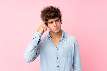 Young caucasian man with jean shirt over isolated pink background making the gesture of madness...