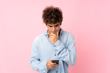 Young caucasian man with jean shirt over isolated pink background thinking and sending a message