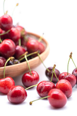 ripe red may cherries on a plate on white background