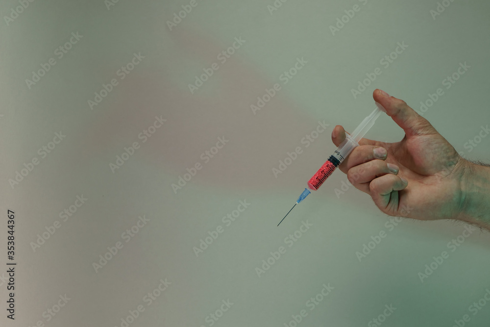 Poster Hand holding creative syringe with red vaccine in the color light. Beautiful. minimal in neon light. Minimalism retro style concept. Background pattern for design.
