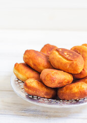 Piroshki - russian baked puff pastry with cabbage fillings. Traditional russian cabbage stuffed baked pastry. lean pies with cabbage. Beautiful homemade cakes with cabbage in metal dishes on white