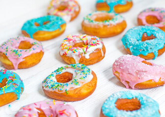 Colorful Donuts turquoise and pink, pattern. Donuts Set on White Background. Doughnuts with multi colored glaze. Doughnuts are traditional sweet pastries. Set of various colorful donuts.