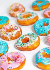 Colorful Donuts turquoise and pink, pattern. Donuts Set on White Background. Doughnuts with multi colored glaze. Doughnuts are traditional sweet pastries. Set of various colorful donuts.
