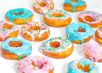Colorful Donuts turquoise and pink, pattern. Donuts Set on White Background. Doughnuts with multi colored glaze. Doughnuts are traditional sweet pastries. Set of various colorful donuts.