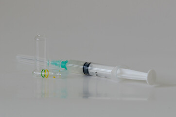 Ampoul, syringe  with needles on white table.