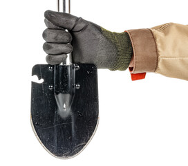 Man hand in black protective glove and brown uniform holding black folding shovel with with...
