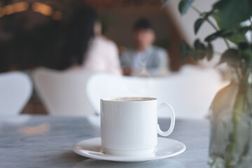 Closeup of cup of coffee on white marble stone table in coffee shop