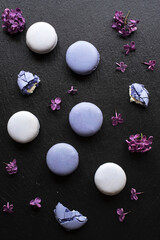 Purple macaroons with lilac on a dark background
