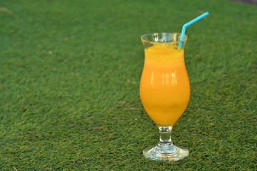 Glass of  fressh orange juice on the grass 