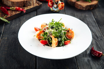 Gourmet arugula shrimp salad in a white plate