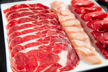 Sliced meat assorti on the white square plate 