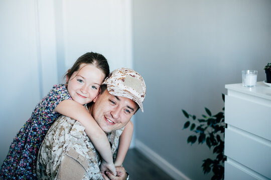 Military man father hugs daughter. Portrait of happy american family.