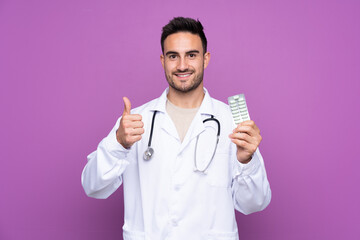 Young man wearing a doctor gown and holding pills