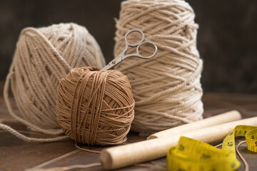 macramé still life - group of cords and threads with scissors and measure tape including wood...