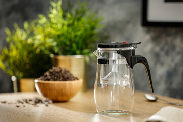 Hot tea on a wooden table in a glass brewer