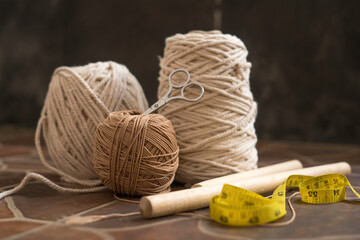 macramé still life - group of cords and threads with scissors and measure tape including wood...