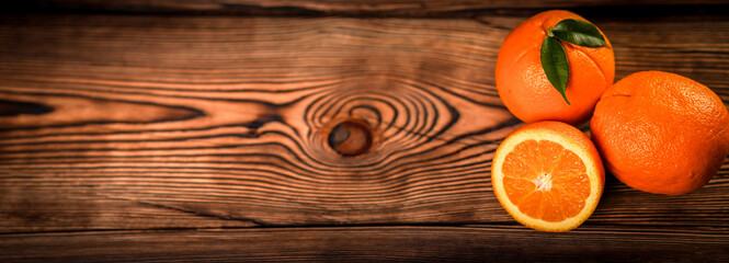 Panorama fresh oranges on old wooden table.