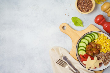 Buddha bowl with buckwheat, tomatoes, cucumber, red sweet pepper, corn and cheese on rustic table. Top view from above