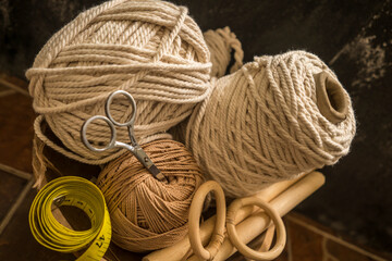 macramé still life - group of cords and threads with scissors and measure tape including wood...