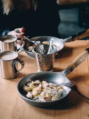 Gnocchi in the pan with female hands in cafe