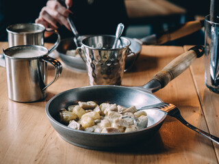 Gnocchi in the pan with female hands in cafe
