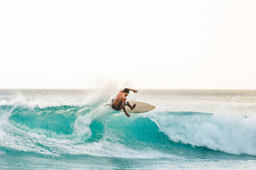 professional surfer riding waves in Bali, Indonesia. men catching waves in ocean, isolated. Surfing...