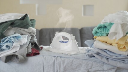 Close up of the iron Smoking and burning on the t shirt and on the Ironing Board