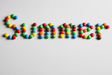 lettering  summer with colorful candies on a white background