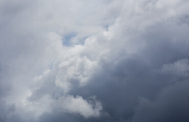 Fluffy clouds cover the summer blue sky